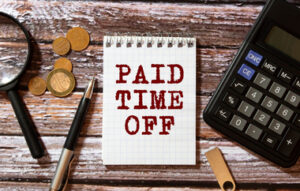 Midsection Of A Businessman Pointing At Paid Time Off Text Over Black Chalkboard.